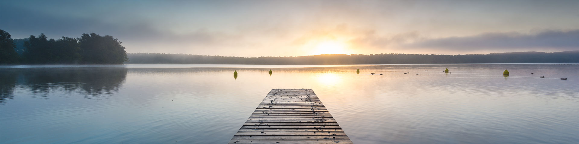 Beerdigungsinstitut: Bootssteg an einem See bei Sonnenuntergang